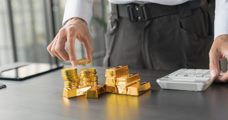 Gold Trading business man hand offering gold Investment in gold mining company or Trading gold on the stock exchange Rising prices